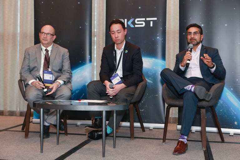 Panel discussion on stage during a Toronto conference, panellists seated with moderator